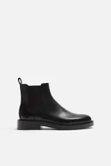 Bota Chelsea marrón de cuero, con elásticos laterales y tirador trasero. Suela negra con ligero tacón.