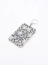 Llavero porta tarjeta rectangular con estampado animal print en tonos beige y negro, con corazones lilas.