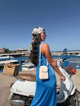 Bandolera pequeña de símil cuero color terracota, con solapa frontal y correa fina ajustable.