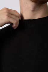 Sweater negro de tejido de punto grueso, corte holgado y cuello redondo.