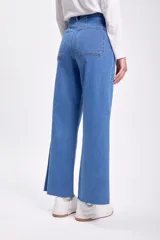 Pantalón jean ancho de tiro alto, color azul medio, con terminación desflecada en el ruedo.