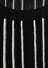 Top negro con rayas verticales blancas, tejido de punto fino, sin mangas y cuello halter.