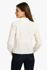 Camisa blanca de algodón con broderie, corte holgado, cuello camisero y cierre frontal con botones.