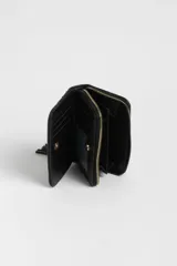 Billetera negra de cuero sintético con diseño capitoneado y tachas doradas. Cierre con cremallera dorada y detalle de borla en el lateral.