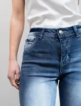 Jean skinny de denim azul con efecto lavado. Pretina con pasadores, botón y cierre. Delantera y trasera con bolsillos.