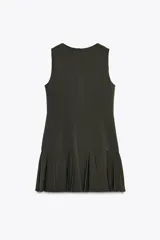 Vestido corto negro sin mangas, con cuello redondo y falda con tablas. Cierre trasero con cremallera oculta.