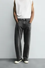 Pantalón de jean gris oscuro, corte amplio, con cinco bolsillos, efecto lavado y cierre frontal con cremallera y botón.