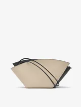 Bolso de hombro de cuero color beige y negro, con forma geométrica asimétrica y asa fina negra.