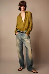 Camisa de lino color verde oliva, con cuello solapa, manga larga con puños y cierre frontal con botones.