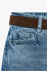 Pantalón de jean azul de corte culotte, tiro alto, pernera ancha y corta. Incluye cinturón marrón de gamuza con hebilla metálica.