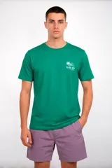 Remera de manga corta color verde esmeralda, con cuello redondo. Presenta un pequeño estampado en el pecho con un diseño de palmera y olas y el texto "WAVES MIAMI".