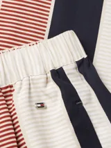 Pantalón de viscosa con estampado de rayas verticales en azul marino, rojo y blanco. Tiene cintura elástica y corte amplio.
