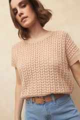 Chaleco tejido color beige con diseño calado, cuello redondo y mangas cortas.