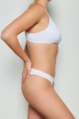 Conjunto de ropa interior blanco, compuesto por un corpiño con aro escondido y una bombacha tipo tanga.