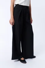 Pantalón de vestir negro de corte palazzo con pinzas en la cintura y bolsillos laterales.