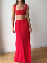 Falda larga tejida color vino tinto con brillo dorado, de corte ajustado y abertura lateral en la pierna.