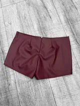 Short color cereza de tiro bajo, confeccionado en tela engomada.
