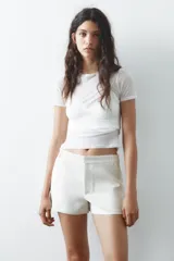 Shorts tiro bajo color negro con bolsillos delanteros. Cierre frontal con cremallera y ganchos metálicos.
