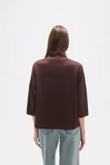 Polera holgada de poliéster color verde militar, con cuello alto tipo tortuga y mangas tres cuartos.