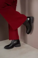 Bota corta color marrón con textura símil cuero de cocodrilo, caña baja, punta redondeada y taco cuadrado.