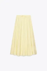 Falda larga color amarillo pastel, de tiro medio con cintura elástica ajustable con lazada y bajo acabado en paneles.