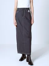 Falda larga Adidas color gris oscuro con finas rayas verticales blancas. Tiene bolsillos delanteros y logo de la marca bordado en el bolsillo trasero.