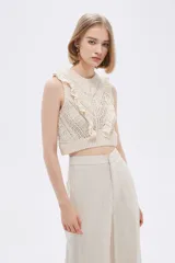 Top cropped color crudo, calado, al cuerpo y cuello a la base, sin mangas y con volados en los hombros.