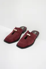 Zuecos con estampado animal print en blanco y negro, con tira ancha de cuero negro y aplique metálico.