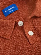 Polo de punto color ladrillo, de manga corta y corte relajado.