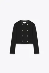 Blazer corta negra de cuello redondo y manga larga, con cierre frontal cruzado con botones dorados y falsos bolsillos delanteros.