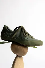 Zapatillas deportivas verde oliva con cordones y suela marrón.