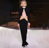 Vestido largo negro con escote redondo, mangas largas y aberturas laterales en la cintura.