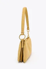 Bolso de hombro color mostaza, confeccionado en gamuza. Tiene asa corta, cierre superior con cremallera y herrajes dorados.