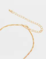 Cadena dorada con dije de strass y corazón de metal.