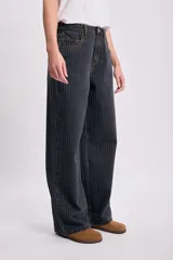 Pantalón de jean negro con rayas verticales blancas, corte recto y tiro alto.