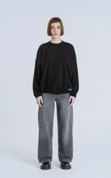 Sweater negro de corte holgado con cuello redondo y mangas largas con puños ajustados.