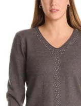 Buzo tejido color gris oscuro, con escote en V y manga larga. Presenta un aplique de tachas en la parte delantera.