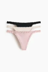 Pack de tres tangas de microfibra en color negro, beige y rosa, con ribetes de encaje y moño decorativo. Modelo de tiro bajo con laterales finos y refuerzo interior.