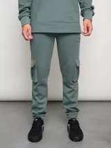 Pantalón cargo verde con bolsillos laterales y logo de la marca bordado.