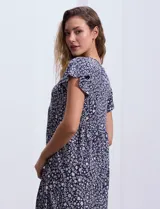 Vestido corto azul con estampado floral blanco, escote en V y mangas cortas.