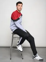 Pantalón de jogging negro con puños ajustados, cortes laterales y cambio de color en la parte inferior de la pierna.