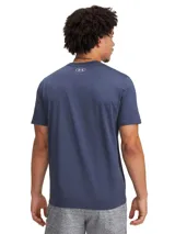 Remera deportiva Under Armour Project Rock, color blanco, de corte clásico y mangas cortas. Presenta un estampado frontal con el logo de Project Rock y la leyenda "Project Rock".