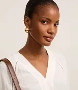 Blusa verde con escote en V, mangas cortas amplias y sisas con entremedios. Confeccionada en viscolino texturizado.