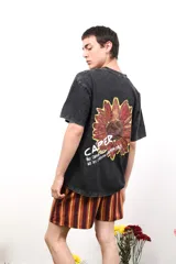 Remera negra de algodón con estampa de un girasol y texto en la espalda. Corte clásico y mangas cortas.