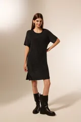 Vestido negro corto de manga corta, holgado y con cuello a la base.