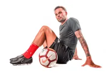Medias de fútbol rojas con detalles antideslizantes en la planta del pie y logo de la marca en el tobillo.