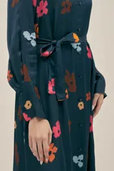 Vestido largo camisero azul marino con estampado floral multicolor, botones nacarados, bolsillos laterales, aberturas laterales y cinturón de lazo.