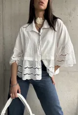 Camisa blanca de mangas 3/4 con detalles de calado en mangas y ruedo.