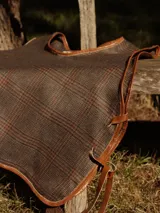 Chaleco marrón con diseño a cuadros y borde de cuero.