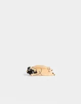 Broche de acrílico color beige con forma de perro pug acostado.